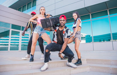 Friends dancing against building in city