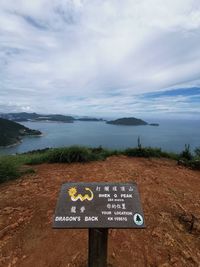 Information sign on lake against sky