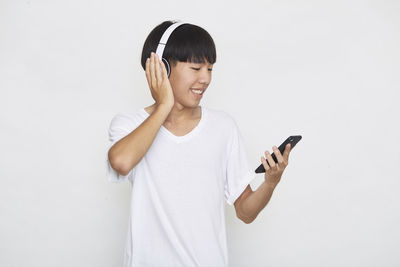 Young man using smart phone against white background