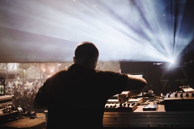 Rear view of dj playing music at festival