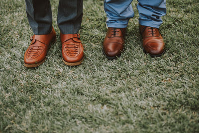 Low section of men standing on grass