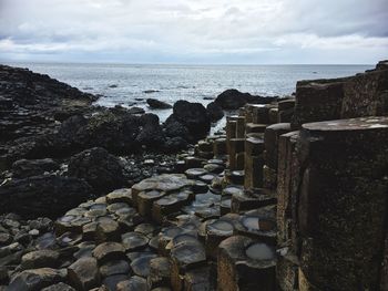 Rocks by sea against sky