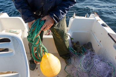 Low section of man fishing in sea