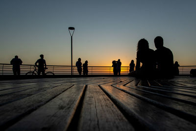 A group of people, in silhouette, is seen enjoying the sunset in the city of salvador, bahia.