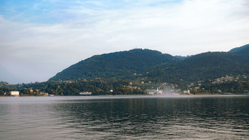 Scenic view of sea by mountains against sky