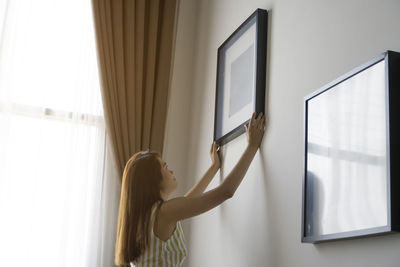 Woman standing by window at home