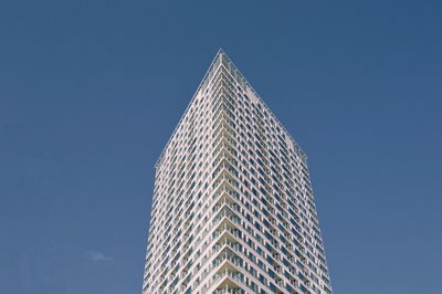 Low angle view of modern building against clear blue sky