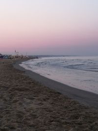 Scenic view of beach against clear sky during sunset