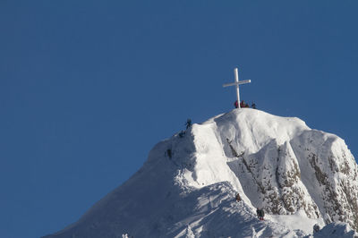 Low angle view of ski lift against blue sky