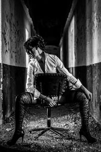 Young man looking away while sitting on chair