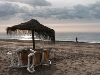 Scenic view of beach against cloudy sky