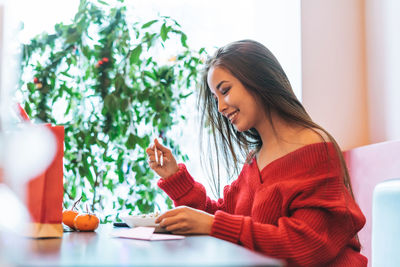 Young woman sitting on table