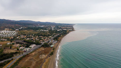 High angle view of townscape by sea against sky