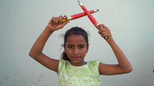 Indian beautiful little girl with garba sticks or dandiya on indian festival navratri.