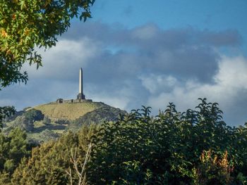 Low angle view of castle on mountain against cloudy sky