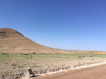 Scenic view of desert against clear blue sky