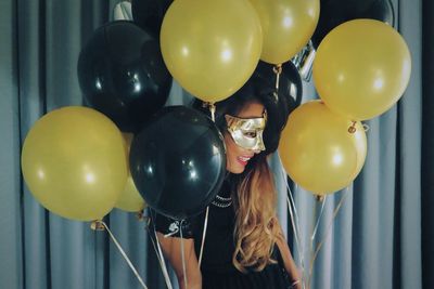 Woman in mask with balloons