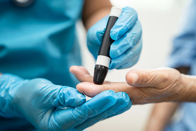 Cropped hand of doctor holding thermometer