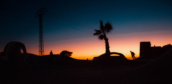 Silhouette palm trees against sky during sunset