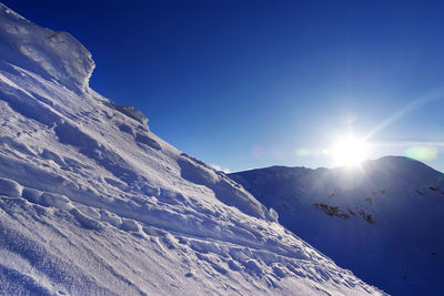 Scenic view of snowcapped mountains against blue sky