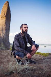 Young man sitting on rock