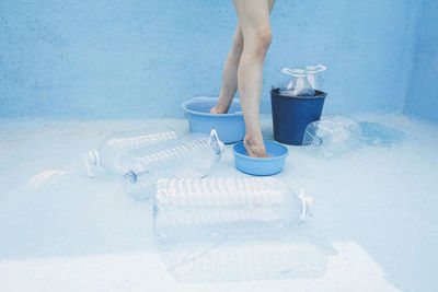 Woman standing inside empty buckets in swimming pool