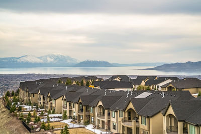 Houses on beach by buildings against sky