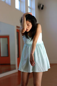 Young woman standing at home