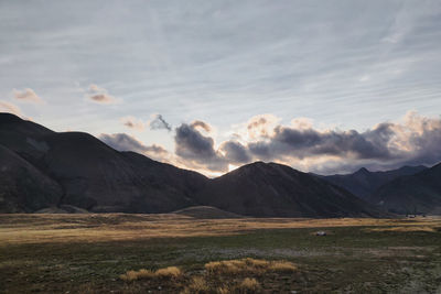 Scenic view of field and mountains against sky