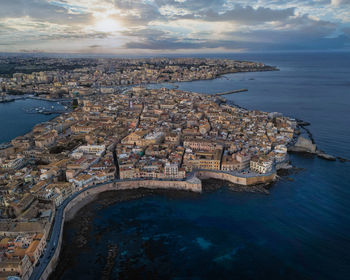 High angle view of city by sea against sky