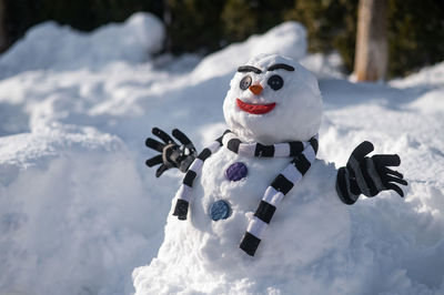 Snowman in a striped scarf. christmas decorations made of snow