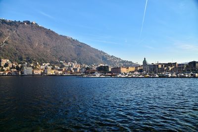 Scenic view of lake by city against sky