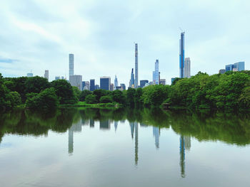 Scenic view of river by buildings against sky