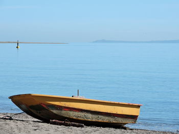 Boat moored on sea against sky