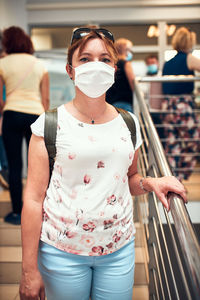 Portrait of woman wearing mask standing in supermarket