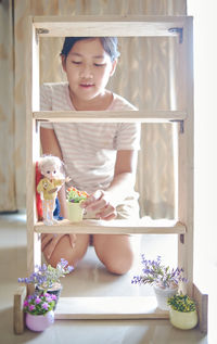 Portrait of young woman standing by window