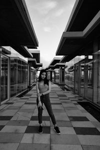 Full length portrait of teenage girl standing on footpath