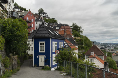 Houses amidst buildings in town against sky