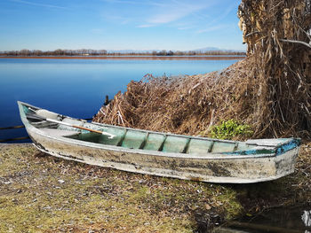 Boat moored on beach against sky