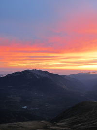 Scenic view of mountains against orange sky