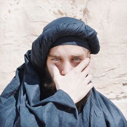 Portrait of man covering face during sunny day