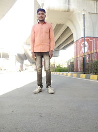 Portrait of young man standing on road