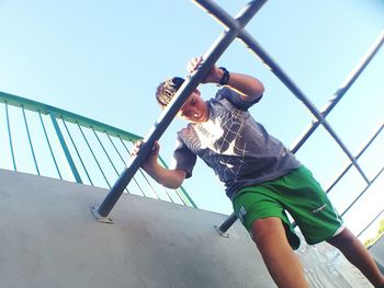 Low angle view of boy standing at jungle gym