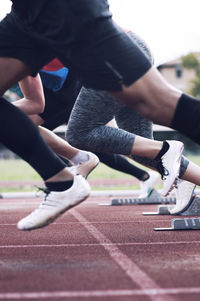 Athletes sprinting from starting blocks on track