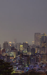 Illuminated buildings in city against sky at night