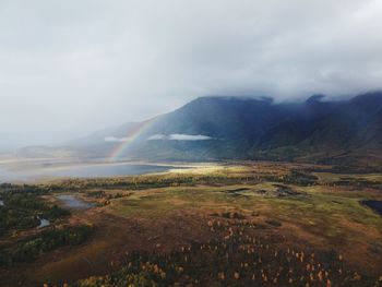 Scenic view of rainbow over mountains against sky