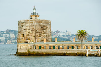 View of building by sea against clear sky