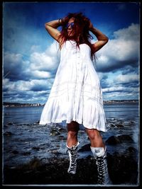 Woman standing on beach against sky