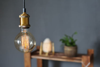 Close-up of light bulb on table at home