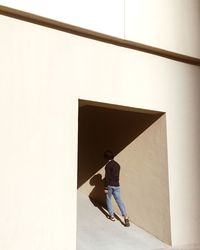 Man with umbrella walking on built structure